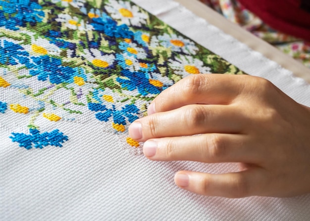 Hands embroidering a floral pattern